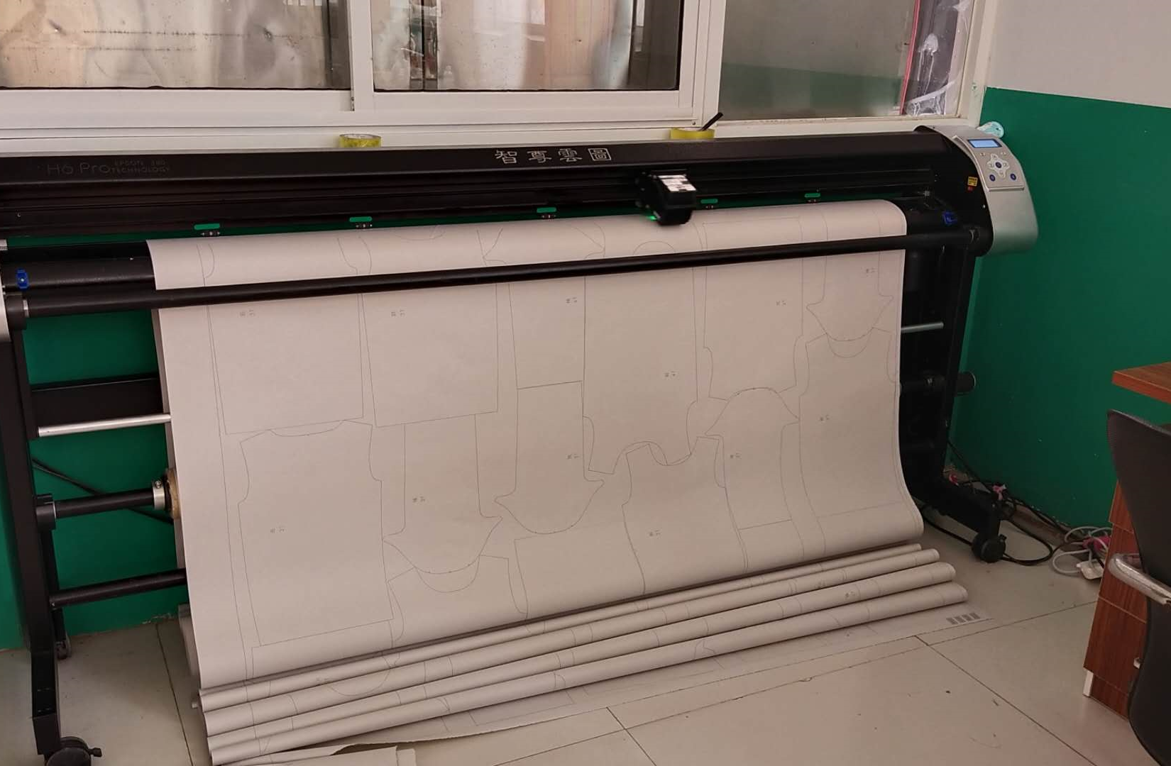 Computerized cutting plotter laying out garment pattern pieces on fabric