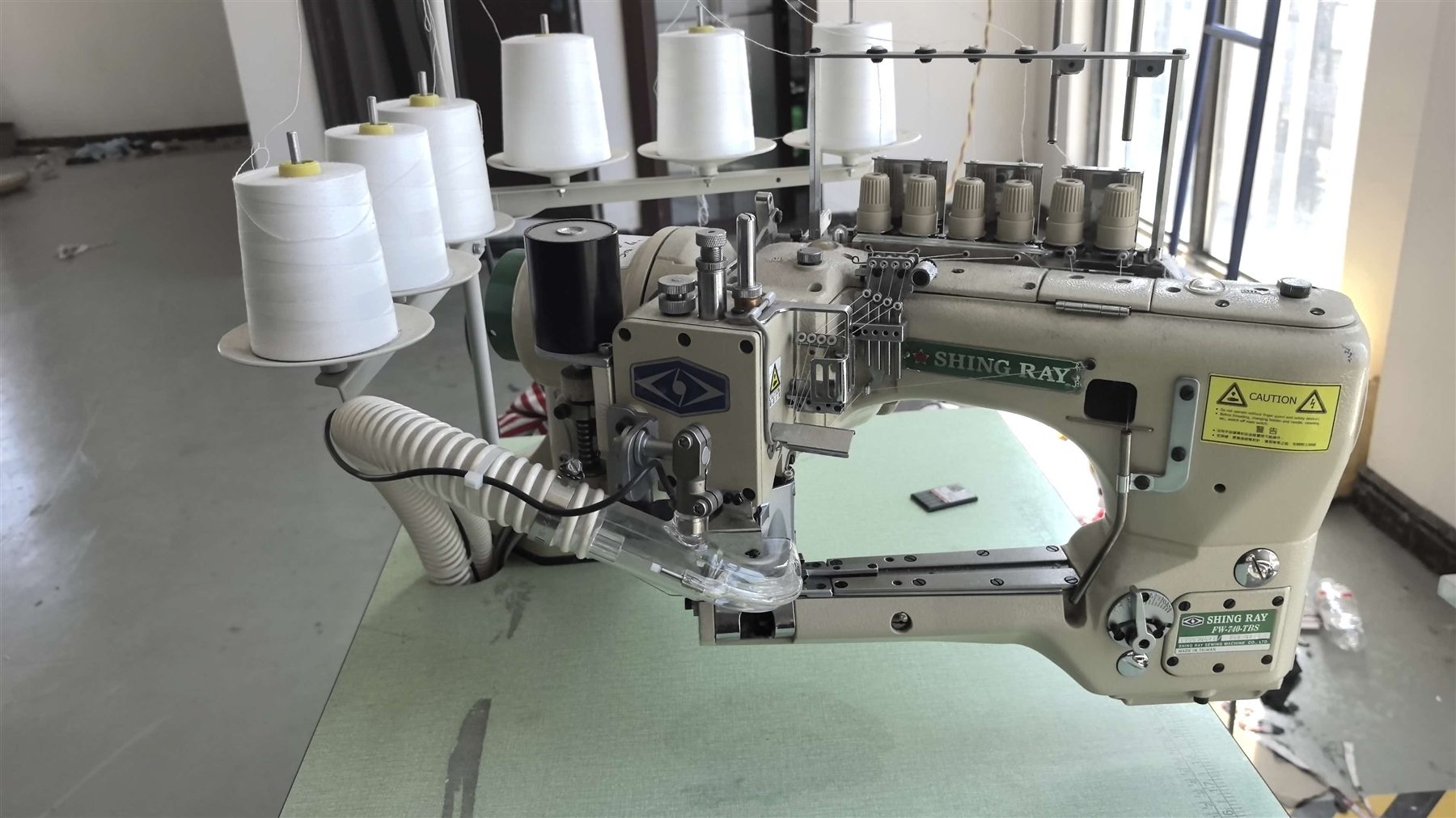 Wide view of FG Knitwear sewing equipment and production workspace
