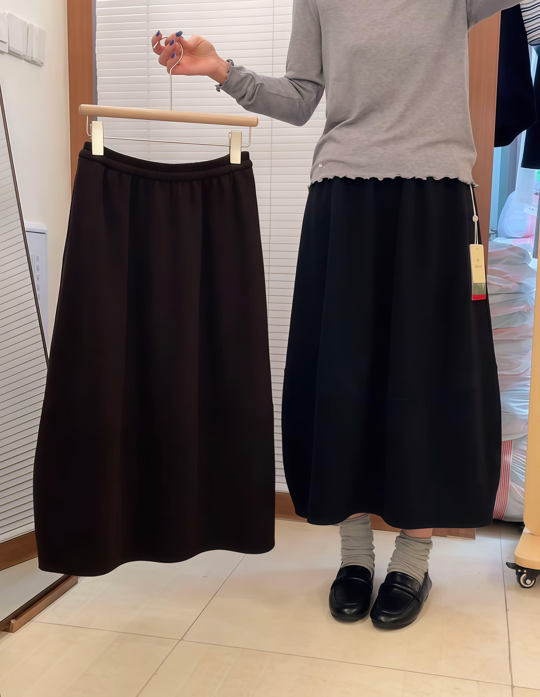 Black long skirt shown both on a hanger and as a worn fit reference